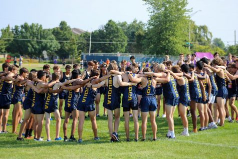 The Neuqua Cross Country team huddles before their race, cheering each other on. 