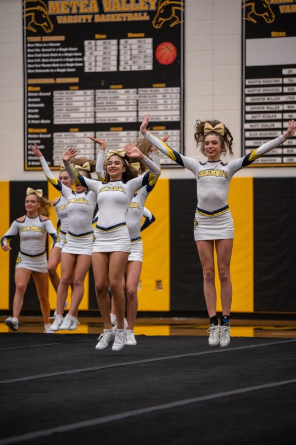 Neuqua Cheerleaders taking the mat during their conference meet