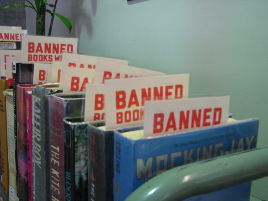 A+collection+of+books+stands+with+a+label+that+connotes+them+as+being+banned.+