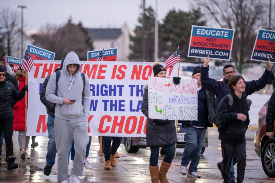 Parents+and+students+stood+outside+Neuqua+Valley+on+a+cold%2C+wet+morning+to+protest+the+districts+mask+mandate.