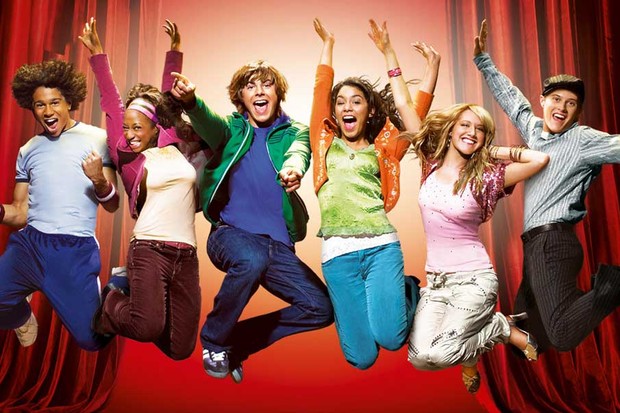 The cast of High School Musical jumps for a movie cover photo.